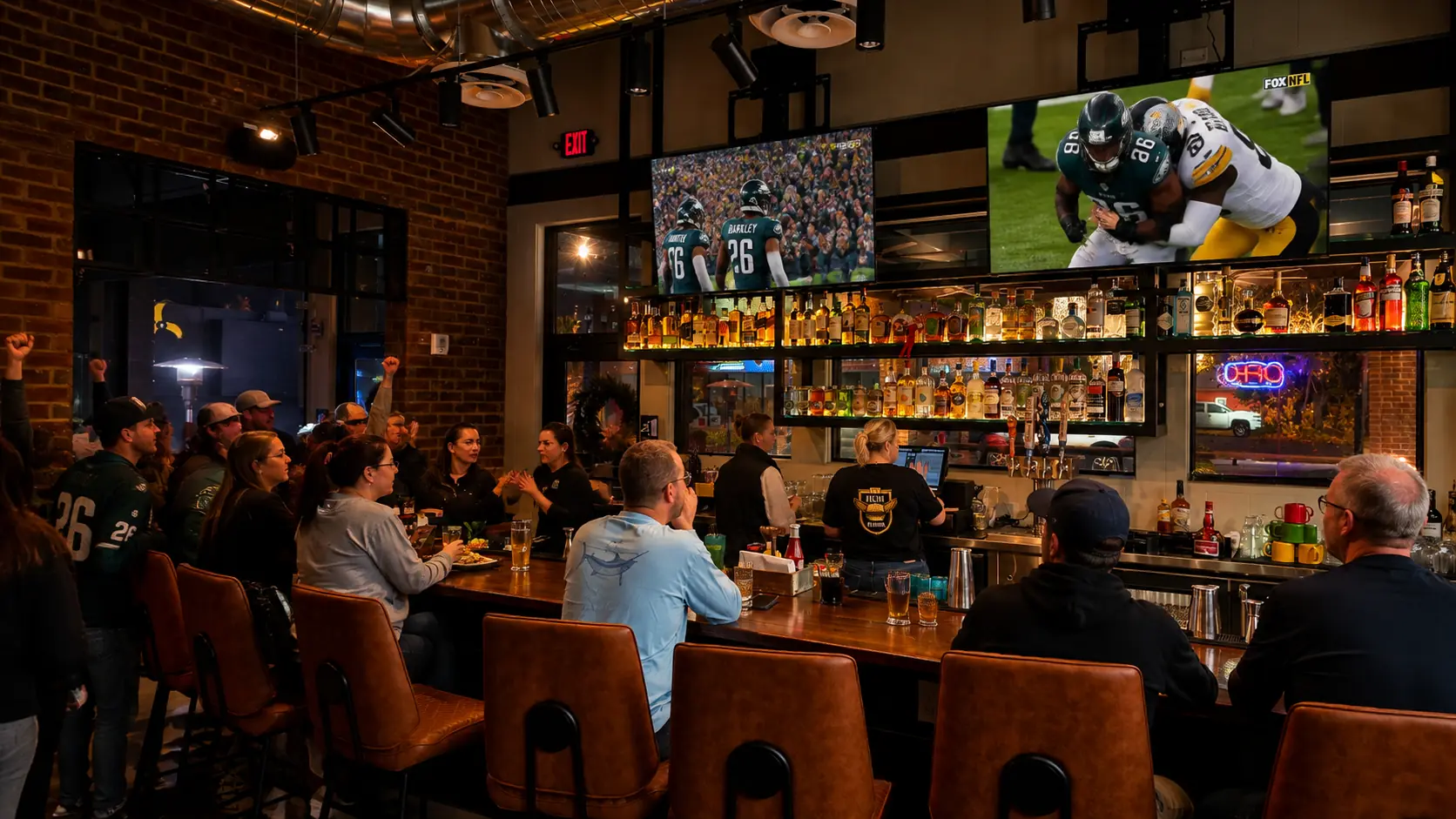A packed night inside The Fillin' Station — the bar, the whiskey wall and the big screens.